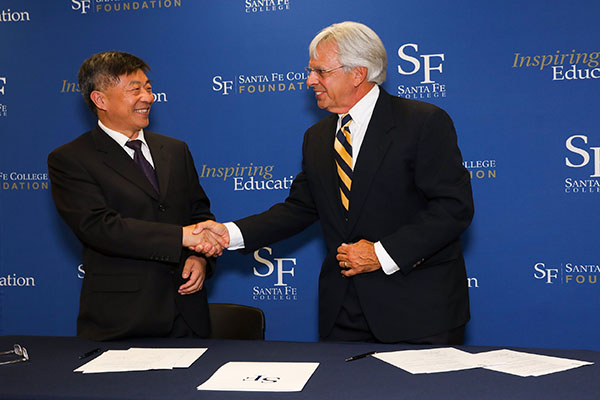 JPEC President Huang Zujie and SF President Jackson Sasser shake hands after signing the articulation agreement
