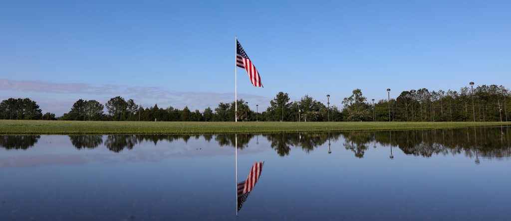 The flag is reflected in a puddle of water after a few days of heavy rain
