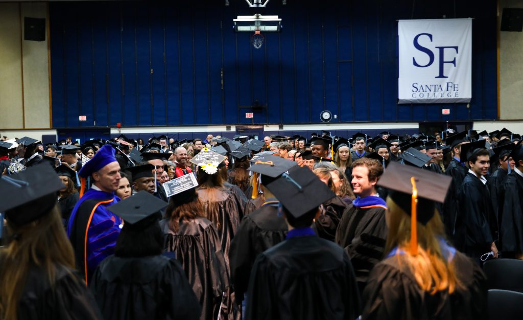 collection of graduates and faculty wearing caps and gowns at graduation at Santa Fe College