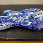 Guitar painted with blue swirl design.