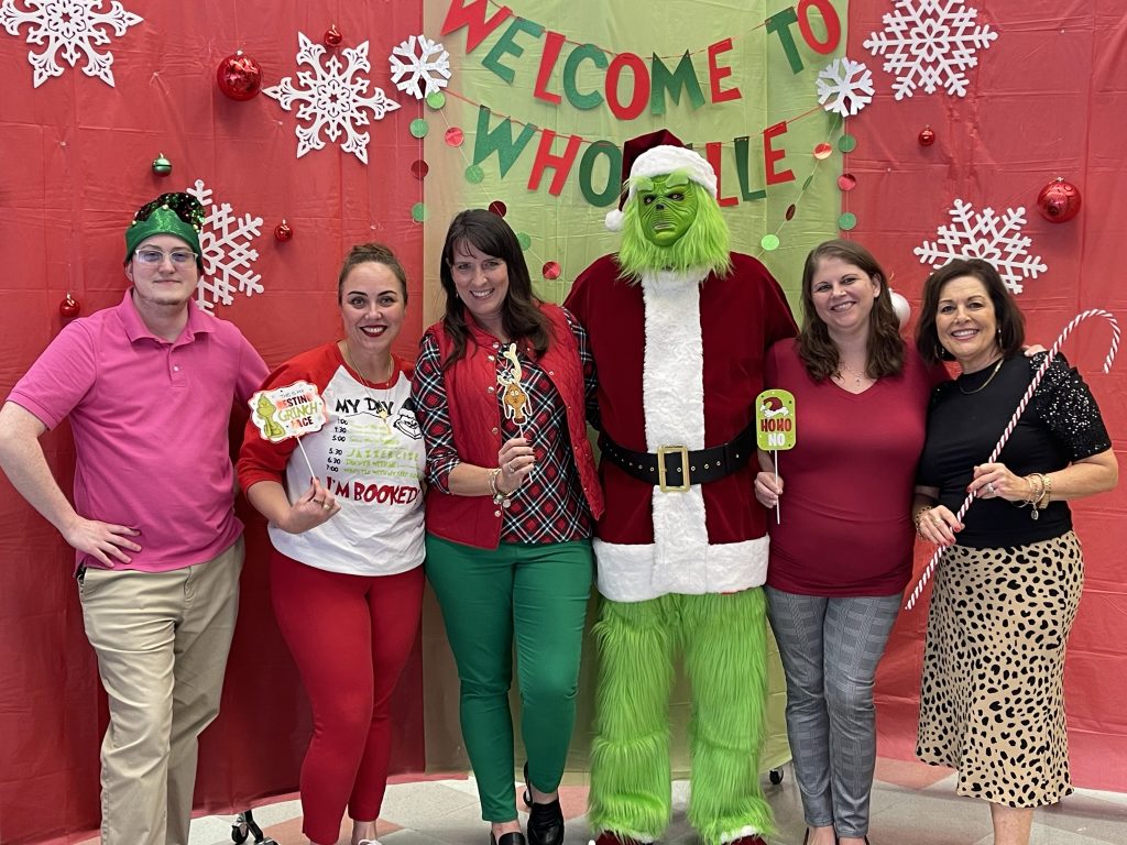 Santa Fe College's HR Department posing with the Grinch.