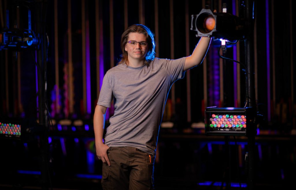 Santa Fe College student Eli Nissley poses for a portrait behind the scenes as a stage tech in the theatre.