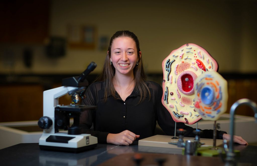 Santa Fe College student Elise O'Hearn sits for a portrait with several science models