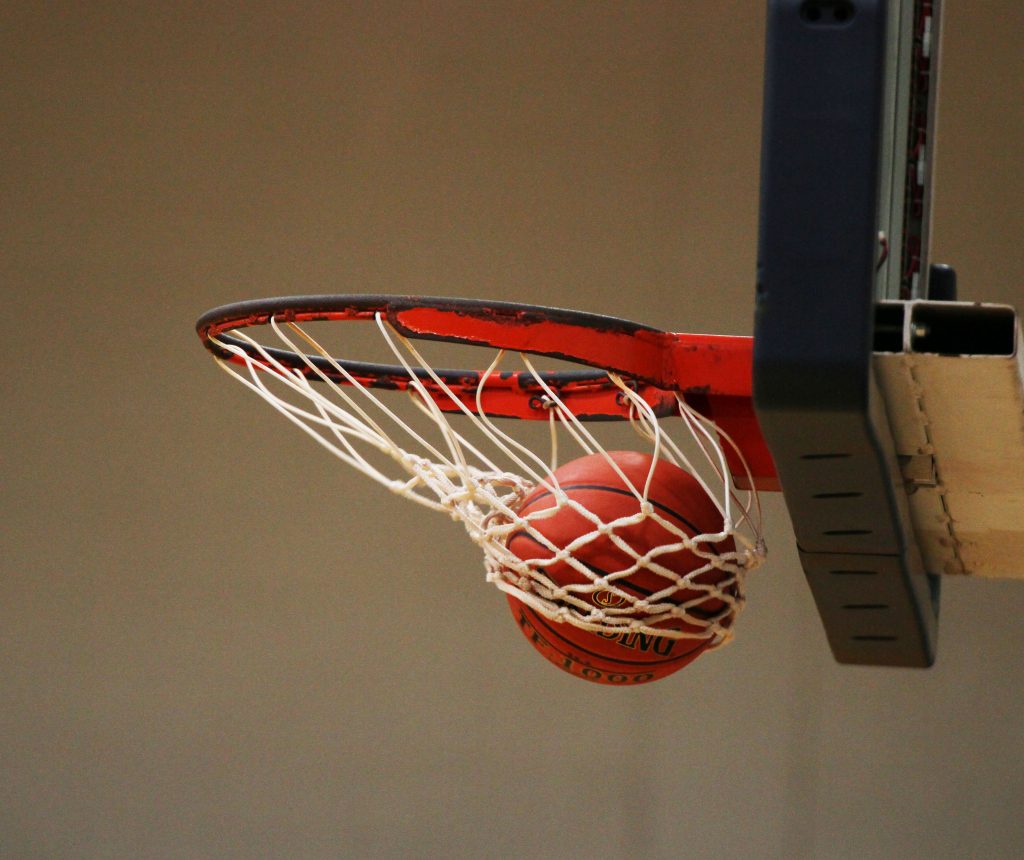 A basketball swooshing into a hoop