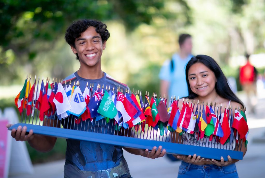 Two individuals holding a tray of flags