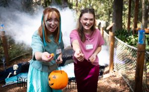 two individuals hand out candy