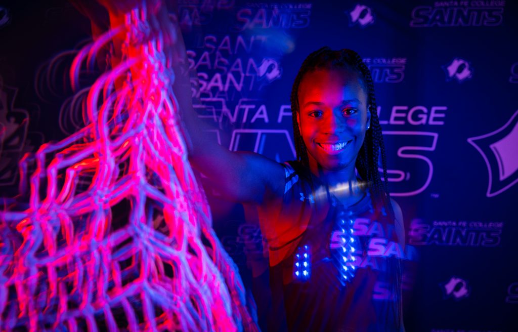 Santa Fe College Saints Women’s Basketball player Shakiria Chaney holding a basketball net