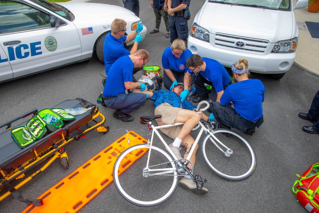 Students at the Institute of Public Safety perform hands-on training on a simulated bicyclist who has fallen outside.