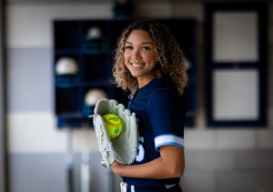 Santa Fe College Saints Softball player Ryleigh Bauer smiles while holding a ball in her glove.