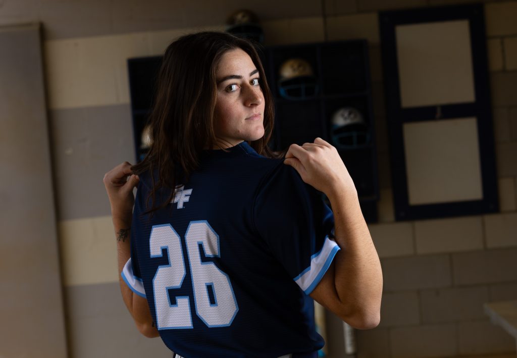Santa Fe College Saints Softball player Mallory Forrester holds the back of their jersey up for the camera.