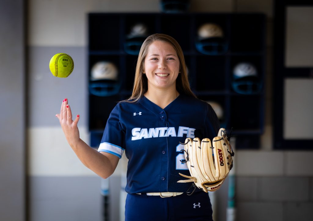 Santa Fe College Saints Softball player Peyton Bass tosses a softball up in the air.