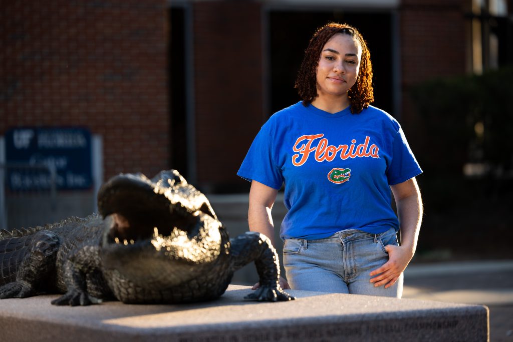 Maya Frazier standing next to a statue of a crocodile