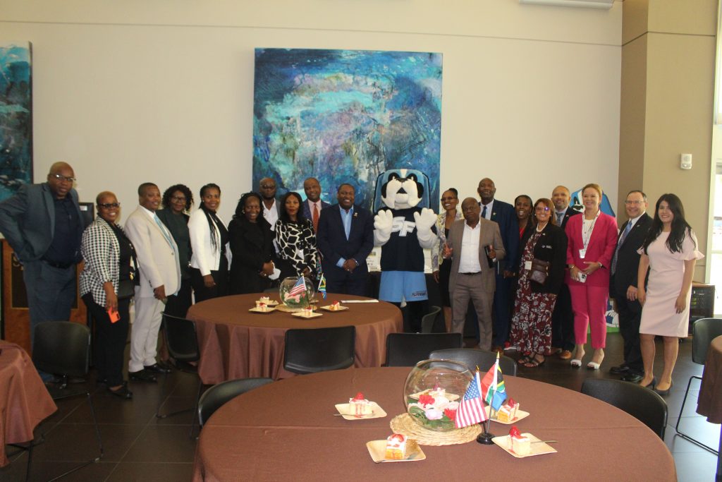 The South African delegation of the Community College Administrator Program (CCAP) stand with Santa Fe College staff in a room.