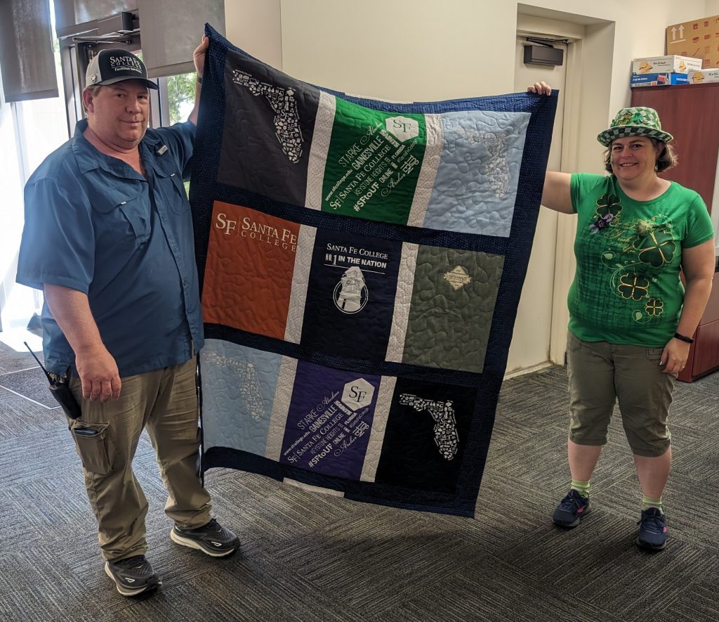 Two people holding a quilt