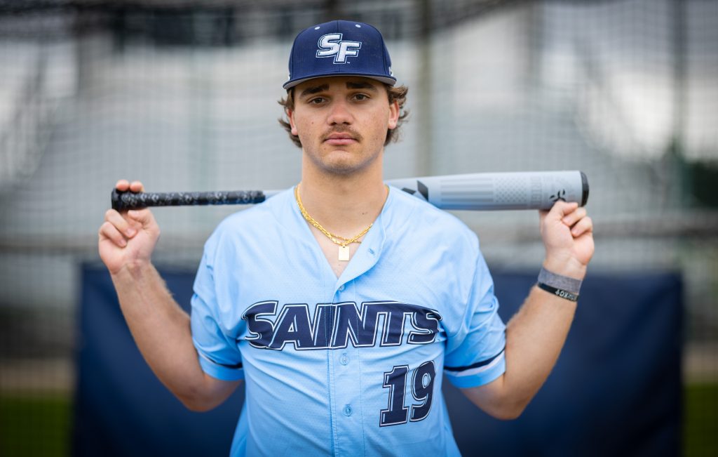 Santa Fe College Saints Baseball player Connor Fosnow holds a baseball bat across his back
