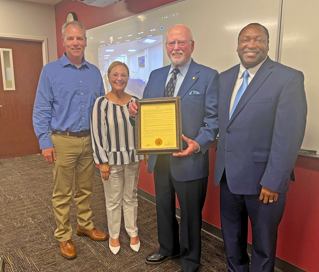Eddie Leach, third from left, poses with Jonathan Miot, Santa Fe College Teaching Zoo Director, SF Board Member Caridad "Carrie" E. Lee, and College President Paul Broadie II, following approval by the Board of a resolution honoring Teaching Zoo founder Ray Giron.