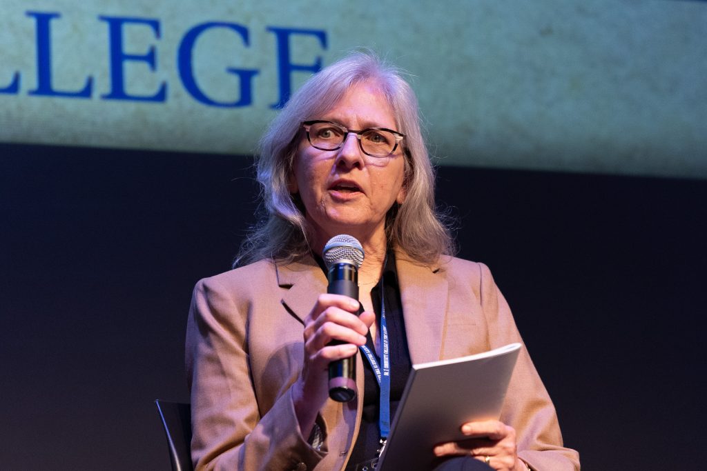 A person holding a microphone and a thin book.